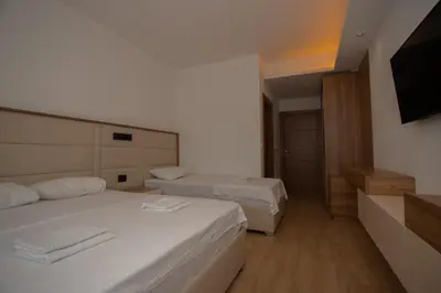 a bedroom with two beds and a flat screen tv at Amber Lux Apartments in Ulcinj