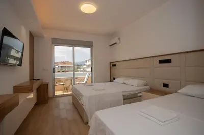 a hotel room with two beds and a television at Amber Lux Apartments in Ulcinj