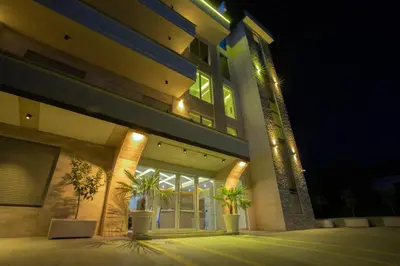 a building with two potted plants in front of it at night at Amber Lux Apartments in Ulcinj