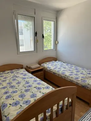 a bedroom with two beds and two windows at Apartment Miricle by the sea 2 in Ulcinj