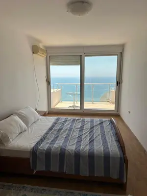 a bedroom with a bed and a large window at Apartment Miricle by the sea 2 in Ulcinj