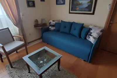 a living room with a blue couch and a table at P&N Bu2 in Budva