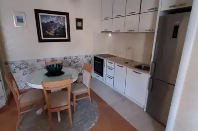 a kitchen with a small table and a refrigerator at P&N Bu2 in Budva