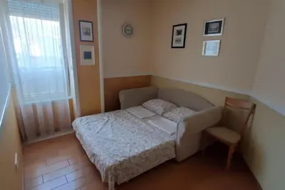 a small bedroom with a bed and a chair at P&N Bu2 in Budva