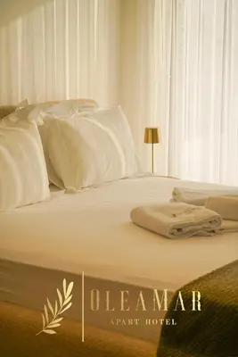 a bed with white sheets and towels on it at OleaMar in Bar