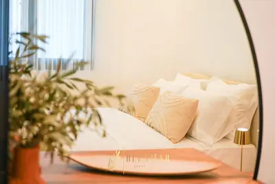 a mirror on a table with a bed with pillows at OleaMar in Bar
