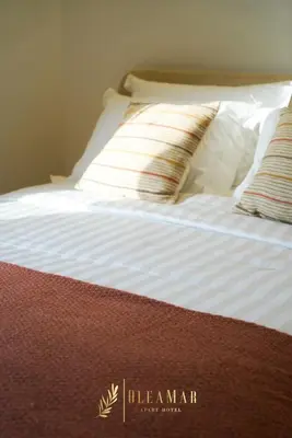 a bed with white sheets and two pillows on it at OleaMar in Bar