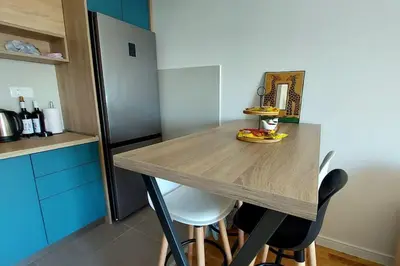 a kitchen with a wooden table and some chairs at Urban Escape Apartment in Pobrežje