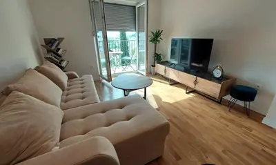 a living room with a couch and a flat screen tv at Urban Escape Apartment in Pobrežje