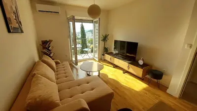 a living room with a couch and a television at Urban Escape Apartment in Pobrežje