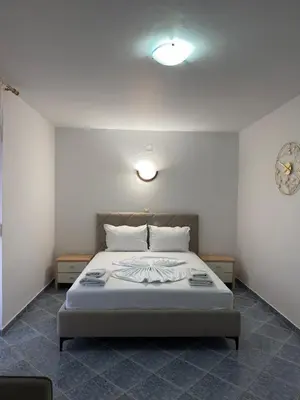 a bedroom with a white bed with two pillows at Velic in Ulcinj