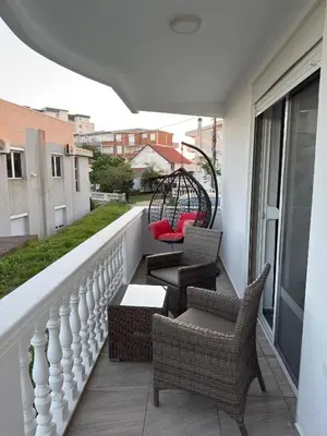 a balcony with chairs and tables and a swing at Velic in Ulcinj
