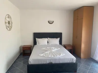 a bedroom with a large bed with a black headboard at Velic in Ulcinj