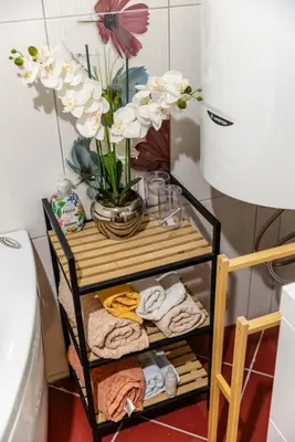 a towel rack with towels and a vase with flowers at LuSi SeaView Apartment in Kotor