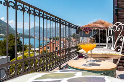 a glass of wine sitting on a table on a balcony at LuSi SeaView Apartment in Kotor