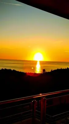 a sunset over the ocean with the sun in the sky at Romantic Hillside Escape Sea View and Infinity Pool in Budva