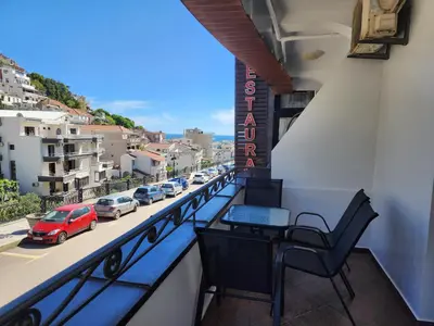 a balcony with a table and chairs and a street at Hana Apartments in Ulcinj