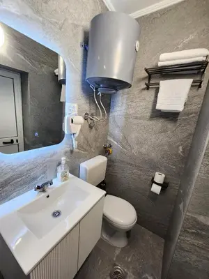 a bathroom with a sink and a toilet and a mirror at Hana Apartments in Ulcinj