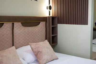 a bed with a headboard and two pillows on it at Hana Apartments in Ulcinj