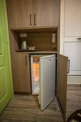 a kitchen with an open refrigerator and cabinets at Hana Apartments in Ulcinj
