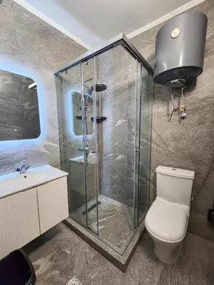 a bathroom with a shower and a toilet and a sink at Hana Apartments in Ulcinj
