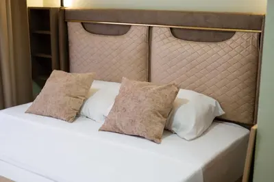 a white bed with two pillows on top of it at Hana Apartments in Ulcinj