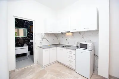 a kitchen with white cabinets and a microwave at Stone Villa with pool Montenegro Star in Kaluđerac