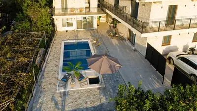 an overhead view of a swimming pool with an umbrella at Stone Villa with pool Montenegro Star in Kaluđerac