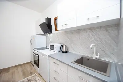 a kitchen with white cabinets and a sink at Stone Villa with pool Montenegro Star in Kaluđerac