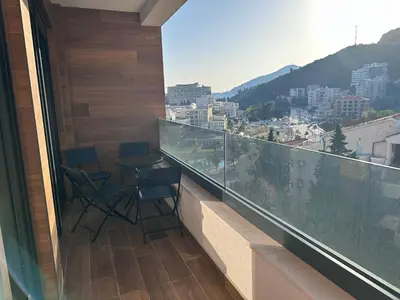 a balcony with chairs and a view of a city at New apartment beach 240m Becici in Becici