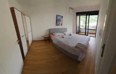 a bedroom with a bed and a wooden floor at New apartment beach 240m Becici in Becici