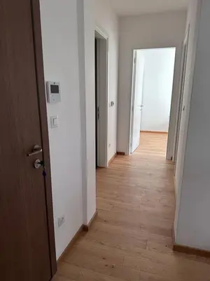 an empty hallway with an open door and wooden floors at New apartment beach 240m Becici in Becici