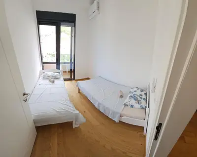 a small room with two beds and a window at New apartment beach 240m Becici in Becici