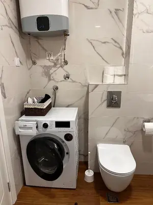 a bathroom with a washing machine and a toilet at New apartment beach 240m Becici in Becici