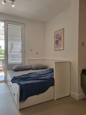 a bedroom with a bed with a blue blanket at Petrovac modern apartment in Petrovac na Moru