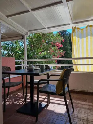 a table and chairs on a patio with a window at Petrovac modern apartment in Petrovac na Moru