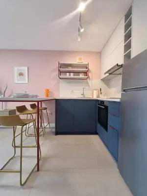 a kitchen with blue cabinets and a table and chairs at Petrovac modern apartment in Petrovac na Moru