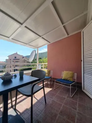 a patio with a table and chairs and a view at Petrovac modern apartment in Petrovac na Moru