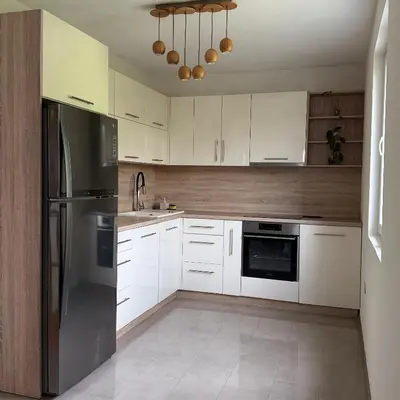 a kitchen with white cabinets and a stainless steel refrigerator at BonacaL&I in Bar