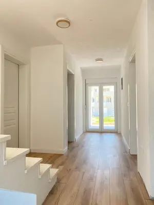 an empty living room with white walls and wooden floors at BonacaL&I in Bar