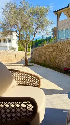 a wicker bench sitting on a sidewalk next to a tree at BonacaL&I in Bar