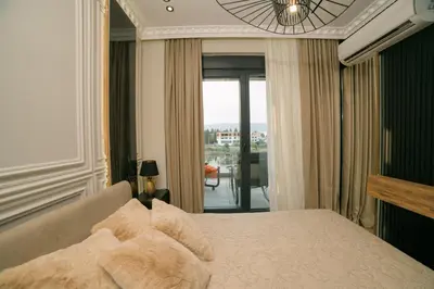 a bedroom with a bed with a view of a balcony at Luxury Apartment with Green Terrace, Porto Milena View and Private Garage in Ulcinj