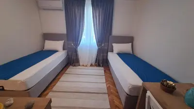 two beds in a small room with blue curtains at Odore di Bar in Bar