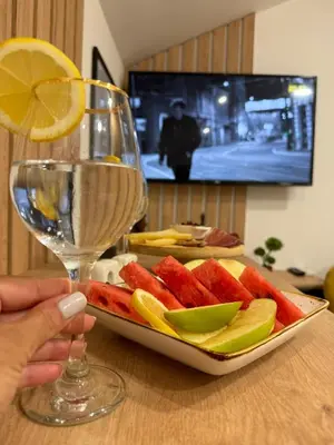 a person holding a glass of wine and a plate of fruit at Oasis of peace in Budva
