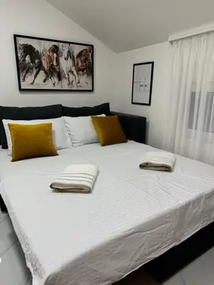 a large bed with two towels on top of it at Oasis of peace in Budva