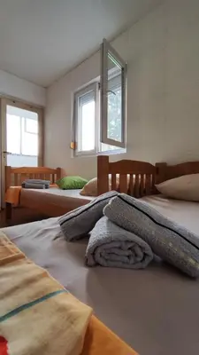 a bedroom with two beds and two windows at Apartman Centar Bar in Bar