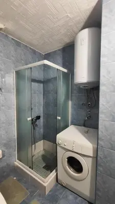 a shower stall with a washing machine in a bathroom at Apartman Centar Bar in Bar