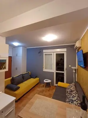 a living room with a yellow couch in a room at Apartman Manja Petrovac in Petrovac na Moru