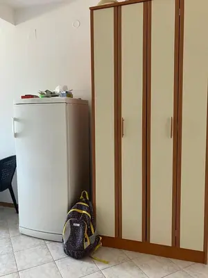a backpack next to a small refrigerator in a room at PePa in Petrovac na Moru