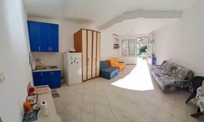 a kitchen with blue cabinets and a living room at PePa in Petrovac na Moru